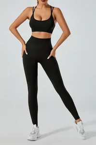 Full-body view of a model in a black two-piece yoga set with sports bra and leggings