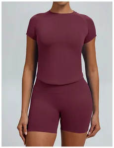 Detailweergave van een bordeauxrood naadloos yoga-set met top met korte mouwen en shorts.