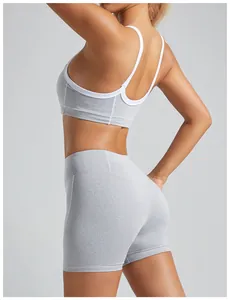 Rear view detail of high-impact gray sports bra with white trim and matching yoga shorts