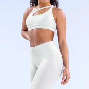 Detalle de sujetador deportivo blanco asimétrico y leggings de yoga de talle alto