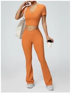 Detailed shot showing the texture of orange high waisted flare yoga pants and crop top