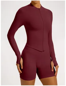 Close-up of burgundy seamless ribbed yoga set showing zipper and thumbhole details.