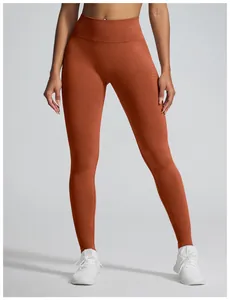 Detailweergave van de naadloze yoga-legging met hoge taille in roestoranje, zachte stof