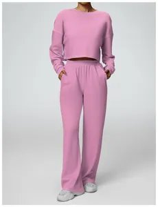 Pink two-piece lounge set with cropped long sleeve sweatshirt and wide leg pants