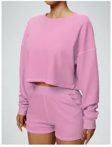 Macro view showing the fabric texture and fit of this pink cropped sweatshirt sports set.
