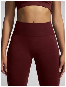 Detailopname van een bordeauxrode naadloze yoga-broek met hoge taille en kationische textuur.