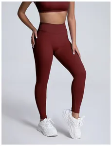 Detailed view of seamless high-waisted burgundy yoga leggings on model with sneakers
