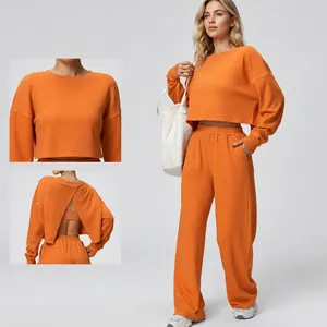 Vibrant orange two-piece sports set with cropped sweatshirt and trendy wide-leg pants.
