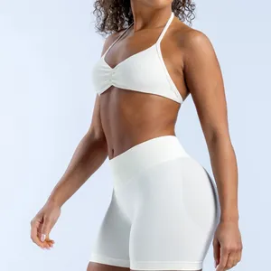 Close-up of white seamless matte nylon yoga halter bra and high-waisted sports shorts