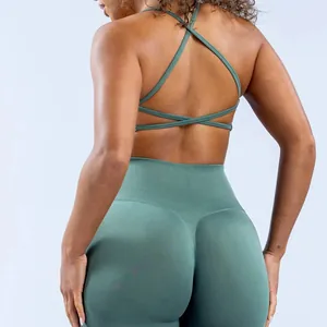 Close-up of sage green yoga bra with criss-cross back straps and seamless leggings