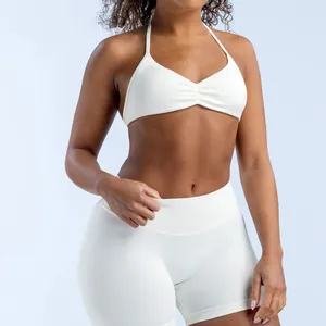 Macro view of a white seamless halter yoga sports bra and matching high-waist fitness shorts