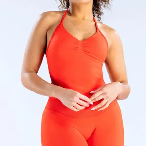 Primer plano de conjunto de yoga naranja con top de cuello halter y mallas de cintura alta
