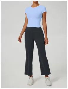 Modella indossa t-shirt yoga azzurra e pantaloni sportivi a zampa grigi