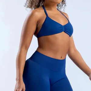 Detail view showing a seamless blue halter yoga sports bra on a female fitness model