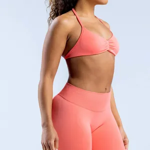Detail view of coral seamless yoga halter bra and high-waisted leggings set