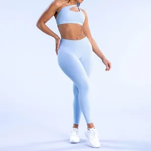 Detalle de conjunto de yoga celeste sin costuras con sujetador halter y mallas altas.