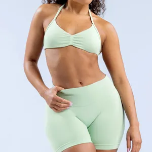 Detail of seamless mint green halter yoga bra and high-waist sports shorts set for women