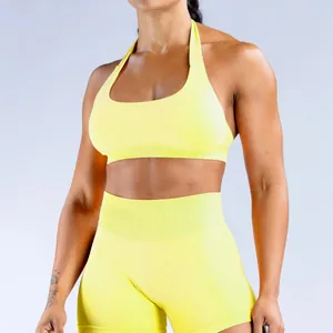 Leuchtend gelbes nahtloses Halter-Sport-BH- und High-Waist-Shorts-Set am Fitnessmodel.