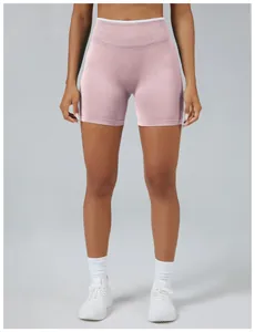 Detail view of seamless pink yoga shorts with high-waisted peach lift design on a model.