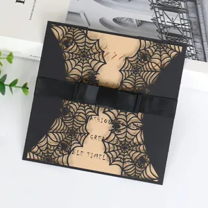 Detailansicht einer lasergeschnittenen Halloween-Einladung mit Spinnennetz und schwarzer Schleife.