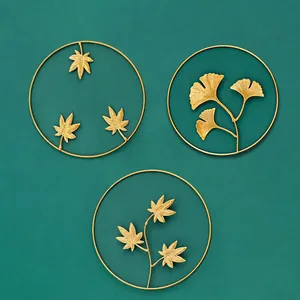 Set mit 3 goldenen Wanddekorationen aus Eisen mit Ahorn- und Ginkgoblättern auf grünem Grund