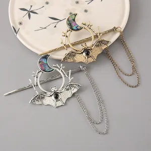 Detailed view of Gothic bat and crescent moon alloy hair sticks in gold and silver finish