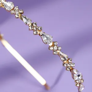 Elegante gouden haarband met druppelvormige strass-steentjes in minimalistische stijl.