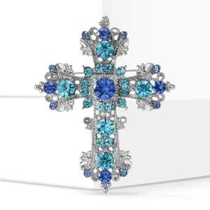 Detailed view of silver alloy cross brooch with sparkling blue and turquoise crystals