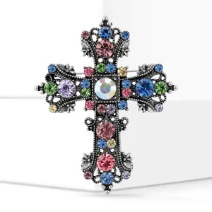 Close-up of vintage alloy cross brooch with multi-color rhinestones and silver finish