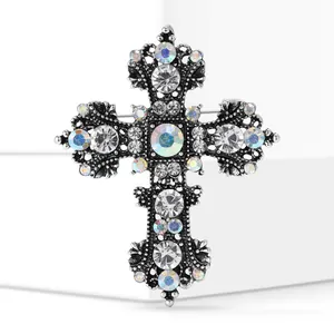 Detailed macro view of an intricate silver alloy cross brooch with sparkling AB crystals.