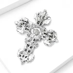 Detailed back view of a vintage silver alloy cross brooch with secure pin.