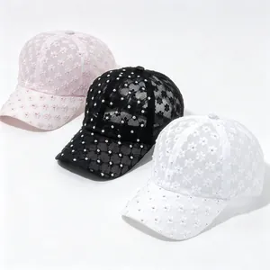 Detail von drei floralen Spitzen-Baseballcaps mit Strasssteinen in Pink, Schwarz, Weiß