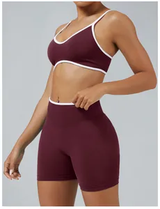 Women's two-piece burgundy athletic yoga set with stylish white contrast trim details