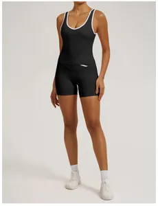 Ganzkörperansicht einer Frau in schwarzem Fitness-Top und Shorts mit weißen Verzierungen.