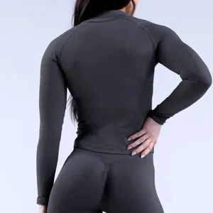 Détail arrière d'un haut de yoga à manches longues sans couture et d'un legging gris foncé