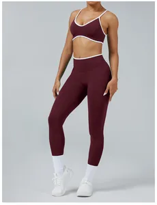 Detail view of seamless burgundy yoga set featuring high-waisted leggings with white trim