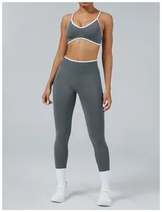 Two-piece grey seamless yoga set with white piping on high-waist leggings and bra