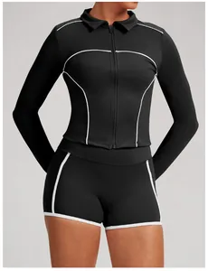 Close-up detail of women's black yoga jacket and shorts set with white contrast piping