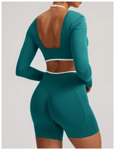 Detailed view of teal seamless long sleeve yoga top with white piping and back cutout design
