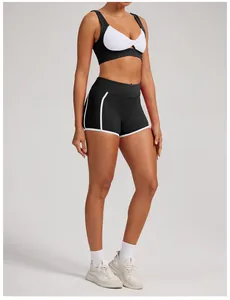 Vista detallada de pantalones cortos de yoga negros de cintura alta con ribete blanco en modelo