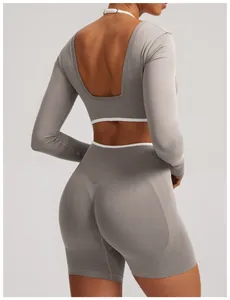 Back view of a seamless long-sleeve yoga top in gray with elegant white trim detail