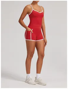 Close-up of red two-piece yoga set with white piping and side pockets on shorts