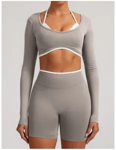 Front view detail of a seamless grey long-sleeve workout set with white trim for women