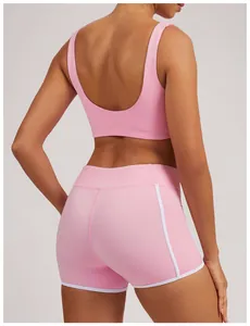 Vista trasera de shorts de yoga rosa de cintura alta con ribete blanco y bolsillo.