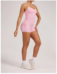 Side view of a woman wearing a pink yoga tank top and shorts set with white piping