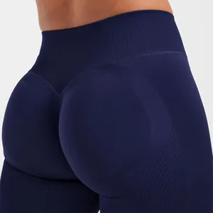 Detailaufnahme der nahtlosen dunkelblauen Yoga-Leggings mit pfirsichfarbenem Gesäß-Design