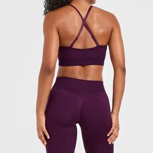 Back view of seamless plum purple sports bra with crossed straps and matching leggings