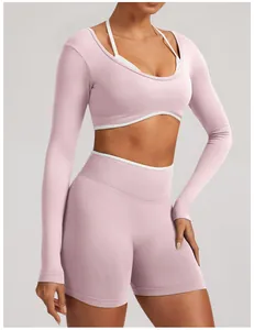 Close-up of pink seamless long-sleeve yoga crop top and high-waist shorts on model