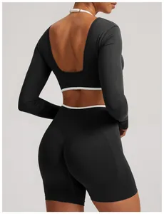 Black seamless yoga set with long sleeve open back crop top and cycling shorts detail