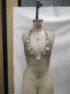 Vue détaillée du gilet chaîne de corps en anneaux métalliques avec pendentifs en coquillage.